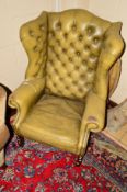 A 20TH CENTURY OLIVE GREEN BUTTONED WING BACK ARMCHAIR (worn but no splits)