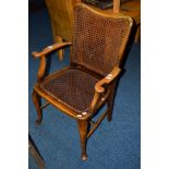 AN EDWARDIAN OAK CANE ELBOW CHAIR