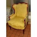 A REPRODUCTION FRENCH WINGED ARMCHAIR with yellow floral upholstery