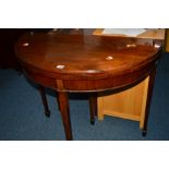 AN EDWARDIAN MAHOGANY DEMI LUNE FOLD OVER TEA TABLE on square tapering legs
