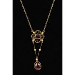 AN EARLY 20TH CENTURY GOLD GEM PENDANT designed as an oval garnet within an open flower shape