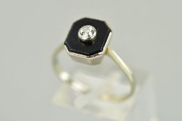 AN ONYX AND DIAMOND RING designed as a central old cut diamond within a collet setting atop an