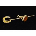 AN EDWARDIAN 15CT GOLD STICKPIN AND A GOLD FOB CHARM, the Edwardian stick pin with a horse shoe