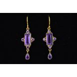 A PAIR OF AMETHYST DROP EARRINGS, the central rectangular amethyst within a four circular amethyst