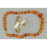 TWO SILVER HINGED BANGLES AND A MODIFIED AMBER NECKLACE, the bangles with engraved decoration to the