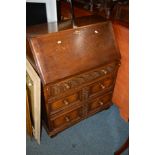 A REPRODUCTION OAK FALL FRONT BUREAU with three exterior drawers (key)