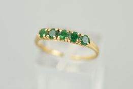A 9CT GOLD FIVE STONE EMERALD RING, the five circular emeralds within claw settings to the plain