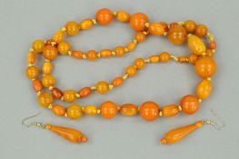 A NATURAL AMBER AND PLASTIC BEAD NECKLACE AND A PAIR OF NATURAL AMBER DROP EARRINGS, the necklace