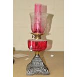 AN OIL LAMP, with ruby coloured funnel and well and similar glass shade, height 47cm