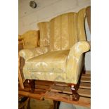 A REPRODUCTION FOLIATE UPHOLSTERED WINGBACK ARMCHAIR on ball and claw feet