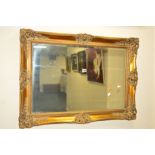 A GILTWOOD AND FOLIATE FRAMED BEVELLED EDGE WALL MIRROR, width 92cm x height 66cm