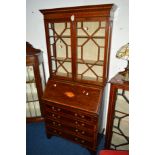 AN EDWARDIAN STYLE MAHOGANY AND INLAID BUREAU BOOKCASE, the astragal glazed double doors revealing