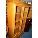 A HARDWOOD GLAZED TWO DOOR DISPLAY CABINET above two long drawers, width 100cm x depth 36cm x height