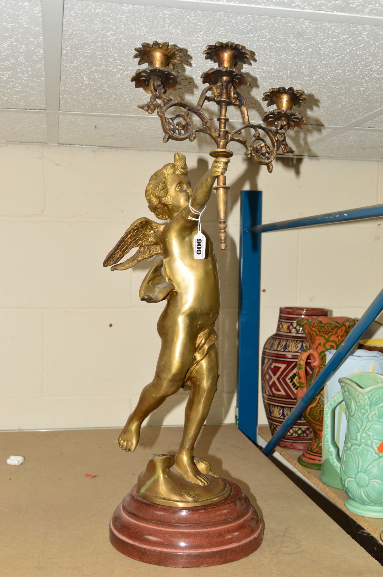 A LARGE BRASS CHERUB, holding a three light candelabra, on plinth, approximate total height 69cm