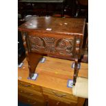 A REPRODUCTION CARVED OAK LIDDED CHEST on raised legs