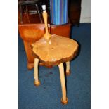 A NATURALISTIC HARDWOOD OCCASIONAL TABLE on triple legs with attached lamp