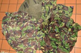 A GREEN CANVAS ARMY ISSUE BAG, containing four pairs of camo trousers, combat NATO DPM and four