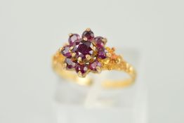 A 9CT GOLD RED PASTE CLUSTER RING, designed with a central circular red paste to the tiered