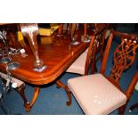 A REPRODUCTION MAHOGANY AND BANDED TWIN PEDESTAL DINING TABLE with a single additional leaf,