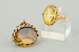 A CITRINE RING AND A CITRINE SWIVEL FOB, the ring designed as an oval citrine within a collet