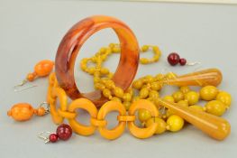 A SELECTION OF PLASTIC JEWELLERY to include a circular disc bracelet in dark yellow bakelite, a long