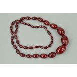 A RED PLASTIC BEAD NECKLACE, the graduated necklace comprising of forty three shape beads