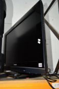 A PANASONIC 32' FSTV (1 remote) and a black glass TV stand (spares or repairs)