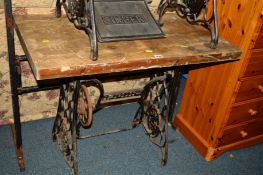 A SINGER TREADLE SEWING MACHINE BASE with a later added wooden top, together with a beech display