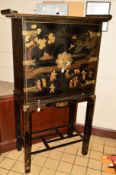 A 20TH CENTURY ORIENTAL BRASS BANDED TWO DOOR CABINET, on a seperate square frame base, black ground