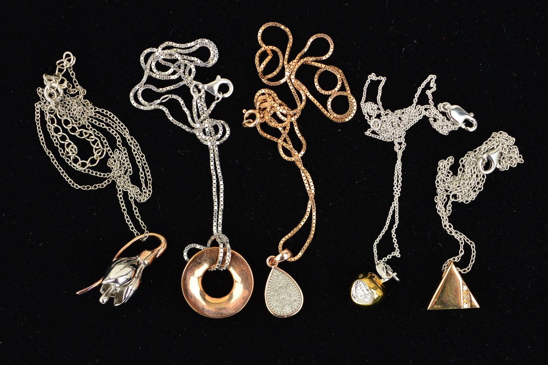 FIVE HOT DIAMOND PENDANTS, one designed as a gold plated apple with a heart shape bite, another a