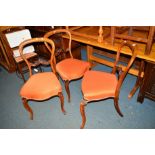 A SET OF FOUR VICTORIAN WALNUT BALLOON BACK CHAIRS with orange overstuffed upholstery (one damaged