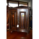 AN EARLY 20TH CENTURY OAK TWO DOOR SMOKERS CABINET revealing two drawers and a separate ash tray