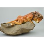A ROYAL DOULTON EARTHENWARE SCULPTURE, 'Lion on Rock' style two, HN2641, by Charles Noke from the