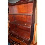 A REPRODUCTION MAHOGANY WATERFALL OPEN BOOKCASE above a single drawer