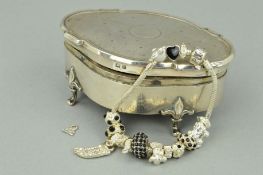 AN EARLY 20TH CENTURY SILVER TRINKET BOX, the oval outline with shaped edging and engine turned