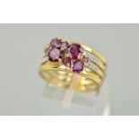 A 9CT GOLD GARNET AND DIAMOND RING, designed as four bands claw set with vari sized circular garnets