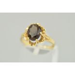 A 9CT GOLD SMOKY QUARTZ RING, the oval smoky quartz within a scalloped claw setting to the