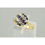 A SAPPHIRE AND DIAMOND CLUSTER RING, designed as three graduated rows of circular sapphires