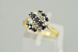 A SAPPHIRE AND DIAMOND CLUSTER RING, designed as three graduated rows of circular sapphires