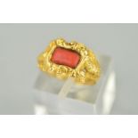 A LATE GEORGIAN GOLD AND CORAL RING, centering on rectangular coral stone (which is a likely later