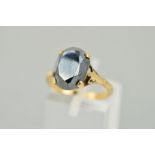 A HEMATITE RING, the faceted oval hematite within a flour claw setting, stamped 9ct, size L 1/2,