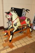 AN EARLY 20TH CENTURY CARVED WOODEN ROCKING HORSE, cream ground with dappled black markings,