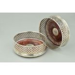 A PAIR OF SILVER AND WOOD WINE BOTTLE COASTERS, the wooden coaster with pierced diamond cross