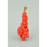 A DYED CARVED CORAL 9CT GOLD PENDANT of elongated outline, the coral carved to depict flowers and