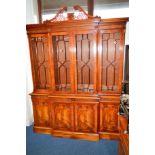 A LARGE REPRODUCTION MAHOGANY AND BANDED BREAKFRONT FOUR DOOR BOOKCASE, swan neck pediment, carved