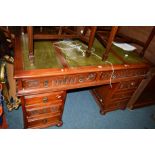 AN OLD CHARM OAK PEDESTAL DESK with triple green leather inlay top and eight various drawers on