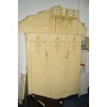 A CREAM AND GILT TWO PIECE BEDROOM SUITE comprising of a three door wardrobe, width 156cm x depth