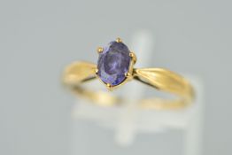 A 9CT GOLD TANZANITE RING, the oval tanzanite within a six claw setting to the tapered shoulders,