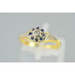A DIAMOND AND SAPPHIRE CLUSTER RING designed as a central single cut diamond within a circular