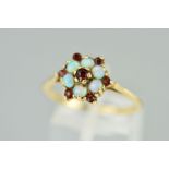 A 9CT GOLD OPAL AND GARNET CLUSTER RING designed as a central circular garnet within an opal